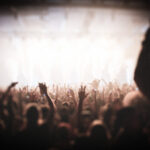 A crowd of people with their hands up at an event